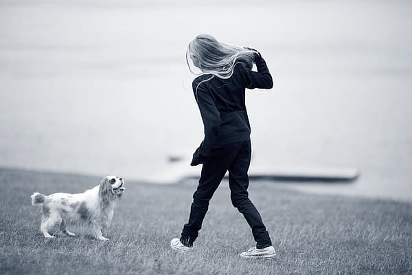 Et barn, der går tur med en hund.