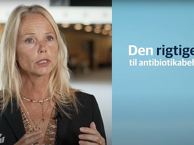 En person med blondt hår og en blå baggrund.