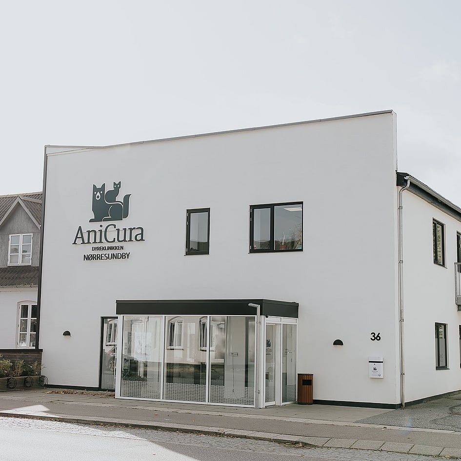 En hvid bygning med logo på forsiden.